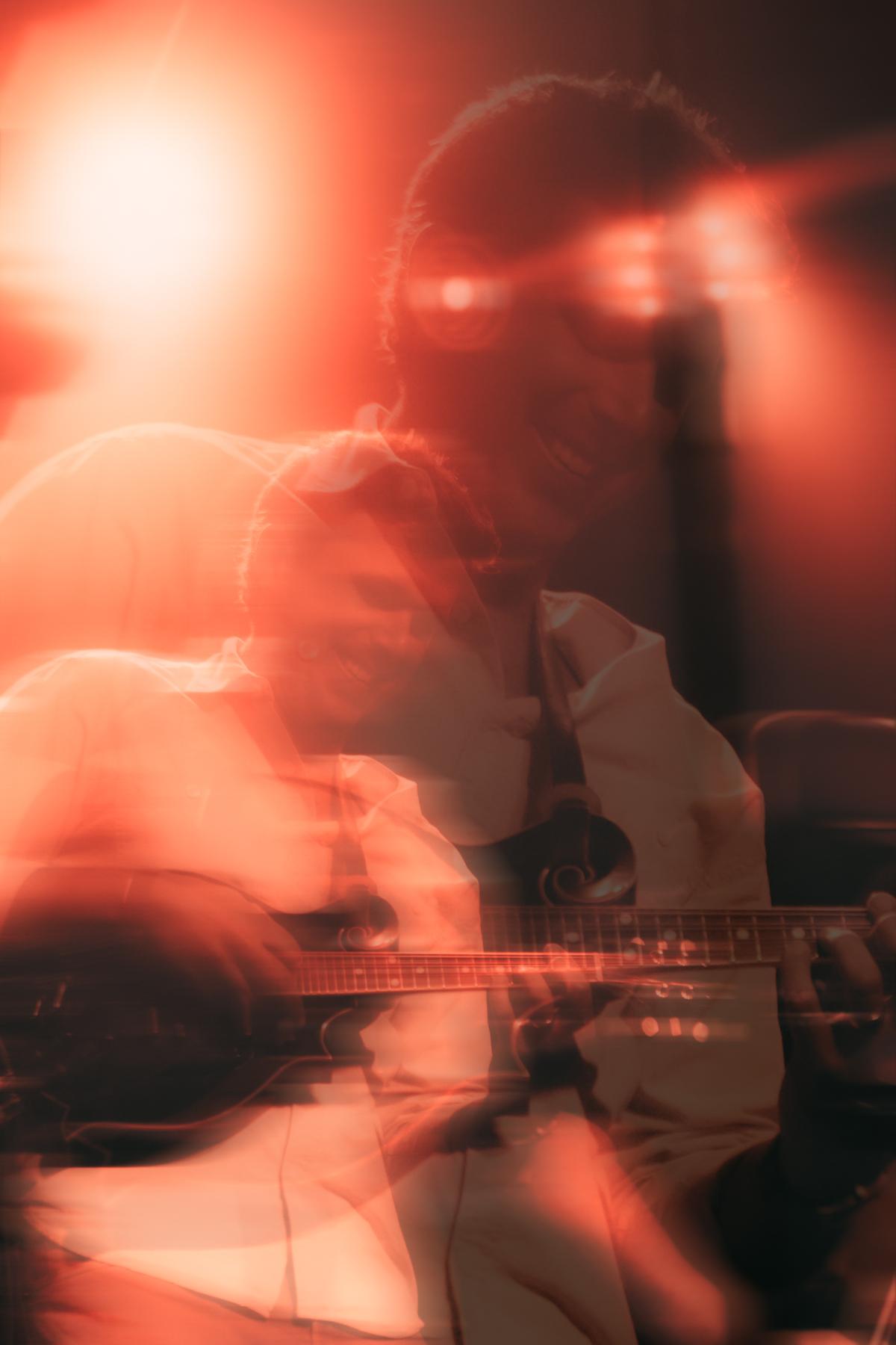 Kyle playing mandolin in a 70s motif at Moe's.