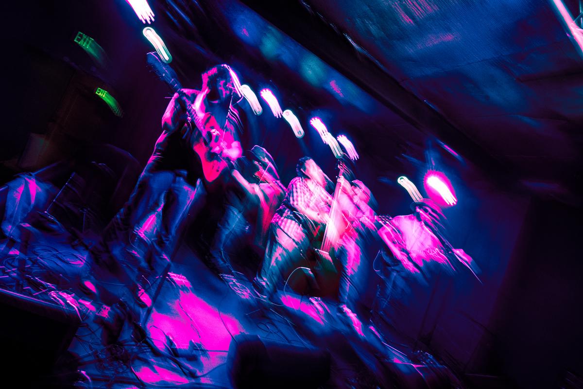 Blurry and colorful pic of the band performing live at Moe's.